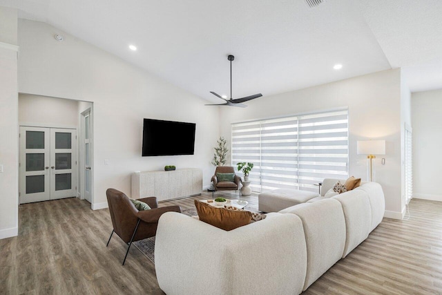 living room featuring light wood-type flooring, ceiling fan, and high vaulted ceiling