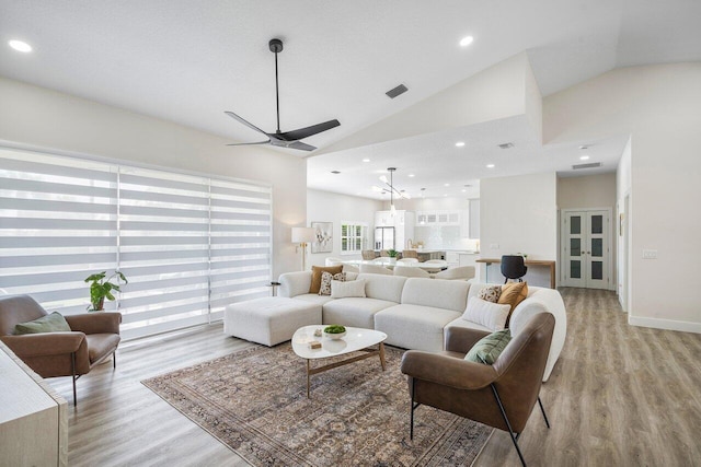 living room featuring light hardwood / wood-style floors, ceiling fan, and lofted ceiling