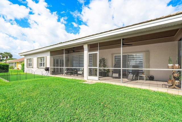 rear view of property featuring a patio area, a lawn, and ceiling fan