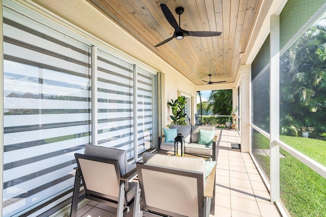 sunroom featuring wood ceiling and ceiling fan