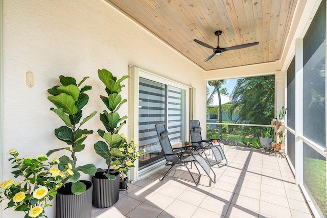 unfurnished sunroom featuring wood ceiling and ceiling fan