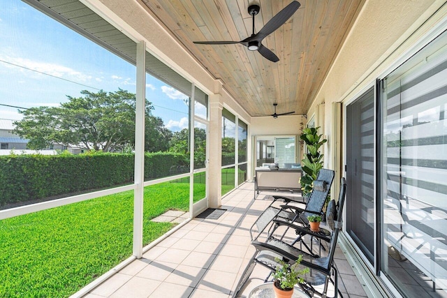 unfurnished sunroom with wooden ceiling and ceiling fan