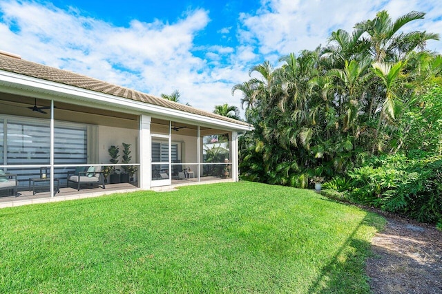 view of yard featuring a patio, a sunroom, and ceiling fan