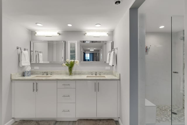 bathroom with vanity and a tile shower