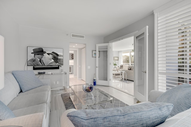 living room with light wood-type flooring and french doors