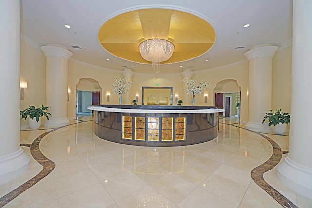 reception area with ornate columns and a notable chandelier