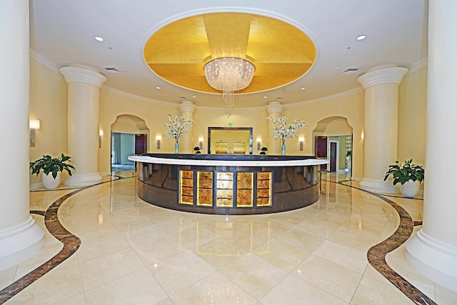 reception area with ornate columns and a chandelier