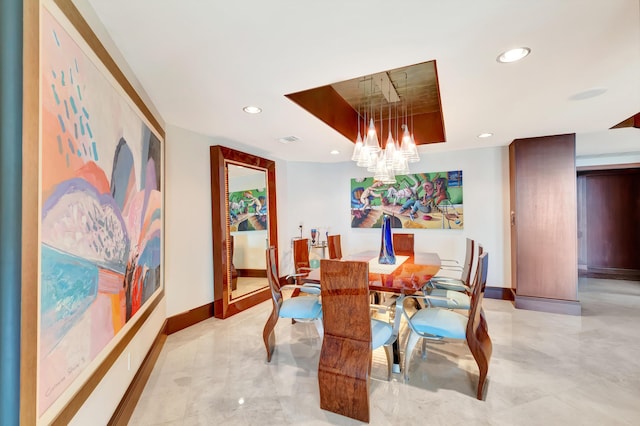 dining area with a tray ceiling and a notable chandelier