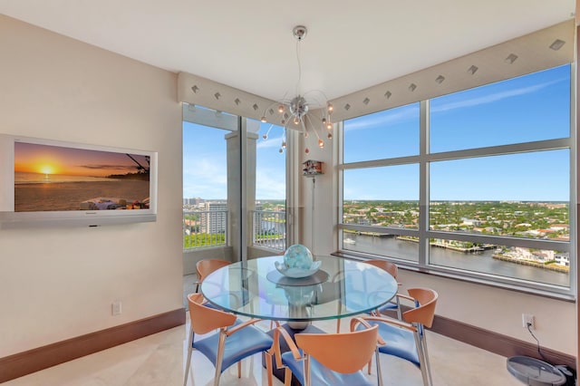 dining room featuring a water view and a notable chandelier