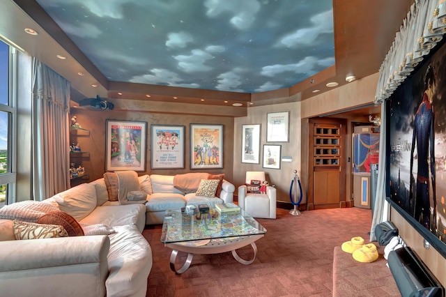 carpeted home theater featuring a raised ceiling