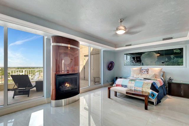 bedroom featuring ceiling fan, access to exterior, and a large fireplace