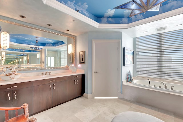 bathroom with a raised ceiling, vanity, a tub, and ornamental molding