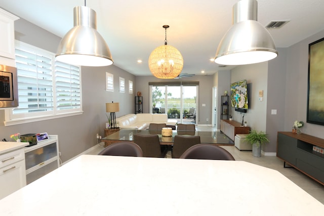 tiled dining space with a notable chandelier