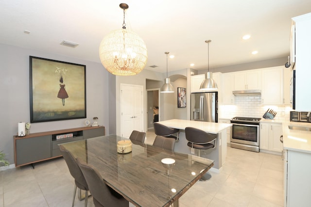 tiled dining space with sink and a chandelier