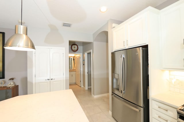 kitchen featuring white cabinetry, stainless steel refrigerator with ice dispenser, light tile patterned floors, and hanging light fixtures