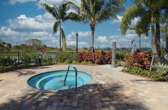 view of swimming pool featuring a hot tub