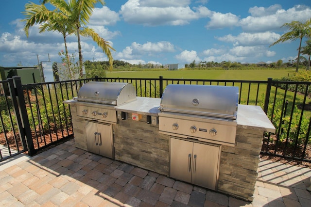 view of patio / terrace featuring a rural view, area for grilling, and exterior kitchen