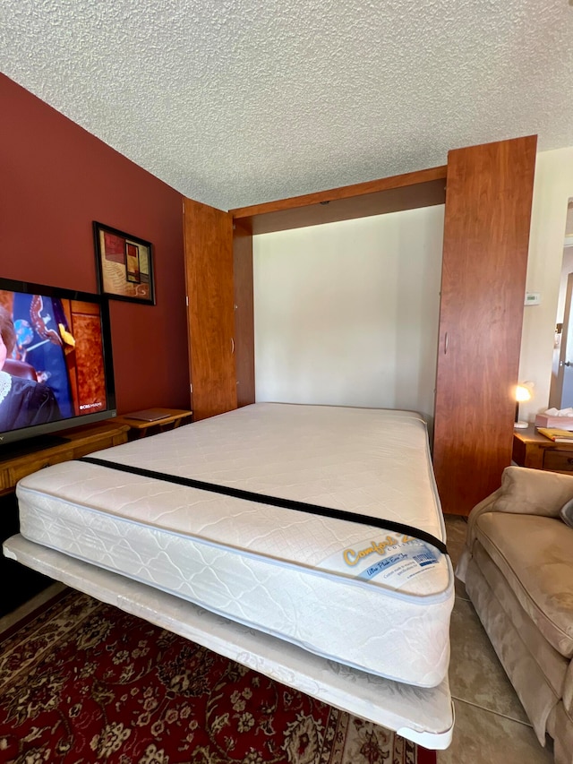 bedroom featuring light tile patterned flooring and a textured ceiling