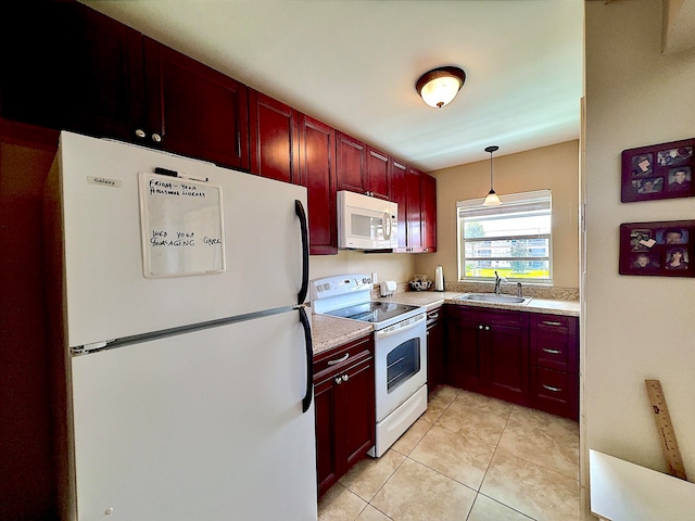 kitchen with sink, light tile patterned flooring, hanging light fixtures, and white appliances