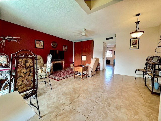 tiled living room featuring a textured ceiling and ceiling fan