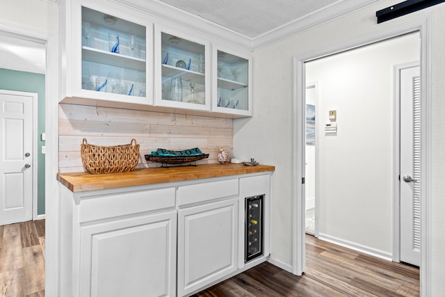 bar with white cabinets, dark wood-type flooring, a textured ceiling, and wood counters