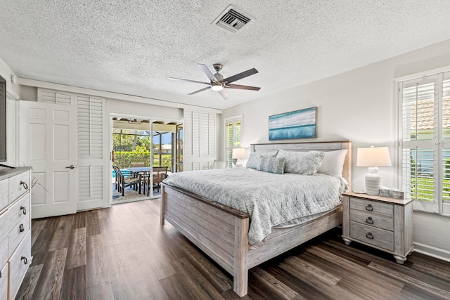 bedroom featuring a textured ceiling, access to outside, dark wood-type flooring, and ceiling fan