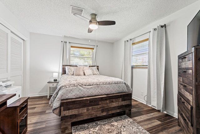 bedroom with dark hardwood / wood-style flooring, a closet, a textured ceiling, and ceiling fan