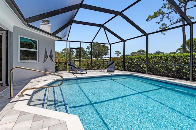 view of swimming pool with glass enclosure and a patio