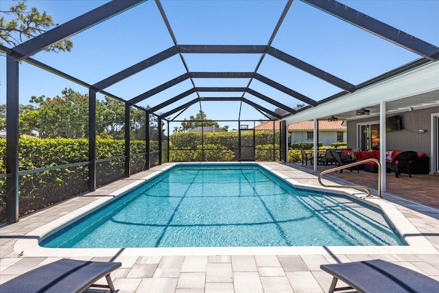 view of swimming pool with ceiling fan, glass enclosure, and a patio area