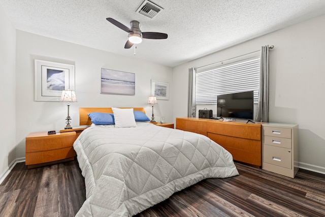 bedroom featuring dark wood-type flooring, ceiling fan, and a textured ceiling