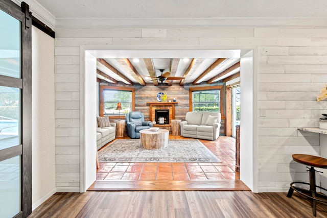 living room with hardwood / wood-style floors, wood walls, and a healthy amount of sunlight