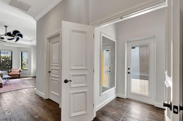 foyer entrance with crown molding and dark hardwood / wood-style floors