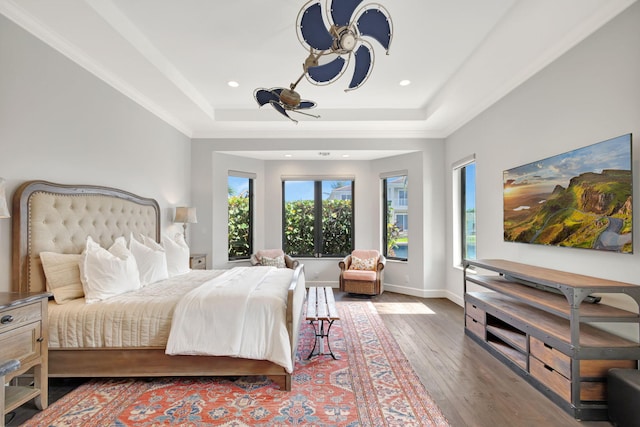 bedroom with a tray ceiling and dark hardwood / wood-style flooring