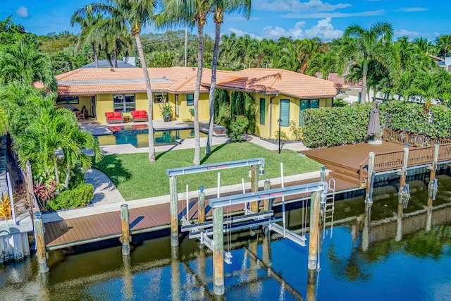 dock area with a yard, a water view, and a patio