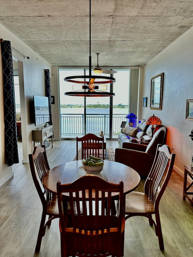 dining space with light wood-type flooring, an inviting chandelier, and expansive windows