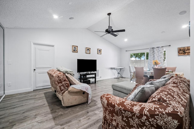 dining area featuring light wood-type flooring, a textured ceiling, and high vaulted ceiling