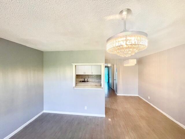 spare room featuring dark wood-type flooring and a textured ceiling