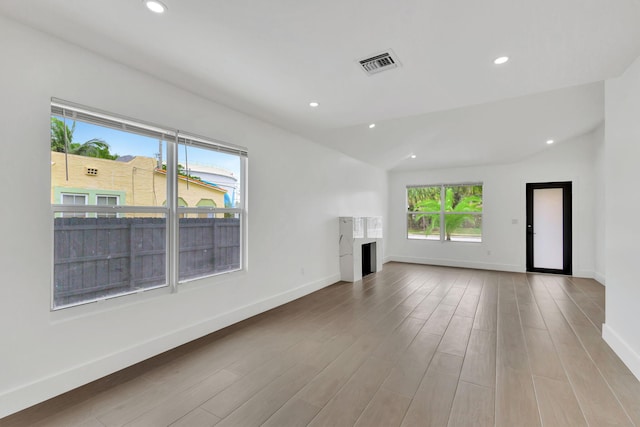 unfurnished living room featuring light hardwood / wood-style floors and vaulted ceiling