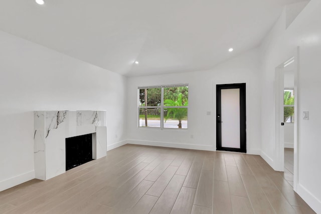 unfurnished living room with light hardwood / wood-style floors and vaulted ceiling