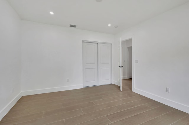 unfurnished bedroom with light hardwood / wood-style floors and a closet