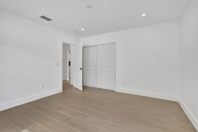 unfurnished bedroom featuring light hardwood / wood-style flooring and a closet