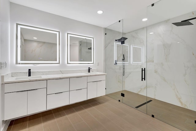 bathroom with a shower with shower door and vanity