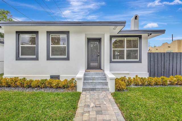 view of exterior entry with a yard