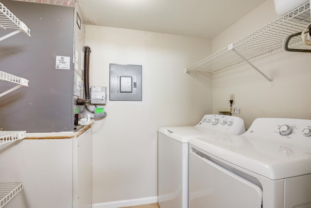 laundry area featuring electric panel, heating unit, and washing machine and clothes dryer