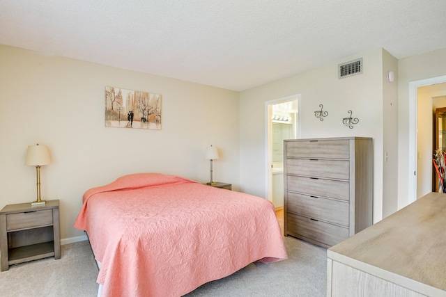 bedroom with connected bathroom, light carpet, and a textured ceiling