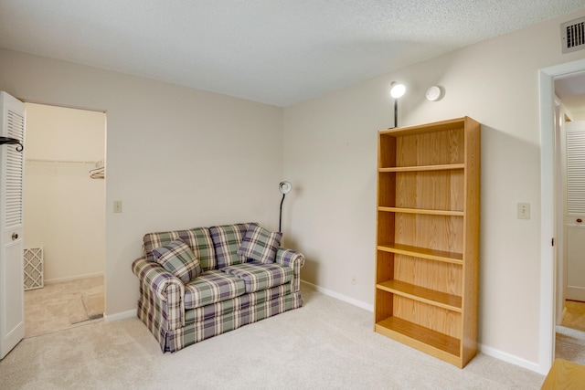 sitting room with carpet and a textured ceiling