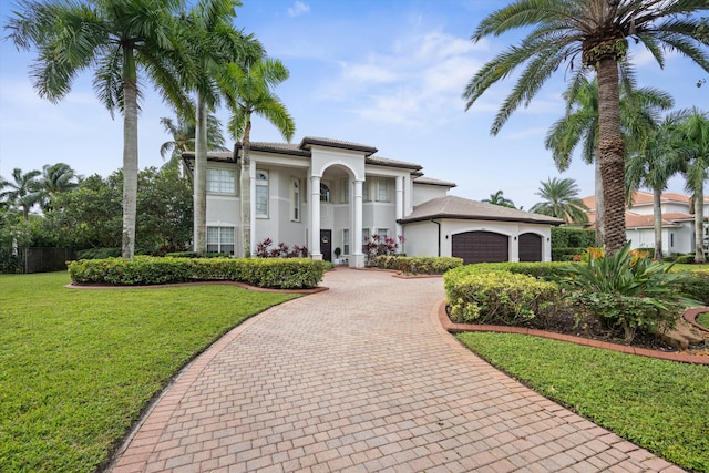 mediterranean / spanish-style home featuring a garage and a front lawn