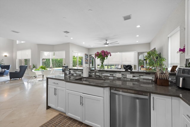 kitchen with dark stone counters, white cabinetry, sink, decorative backsplash, and dishwasher