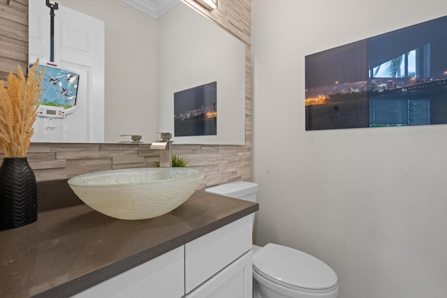 bathroom with crown molding, decorative backsplash, vanity, and toilet