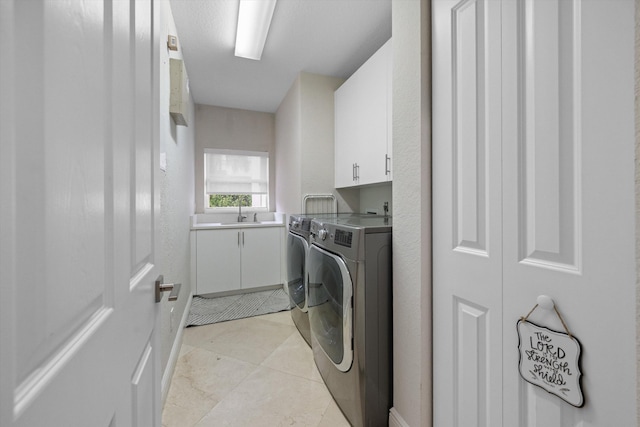 clothes washing area with cabinets, light tile patterned flooring, washer and dryer, and sink